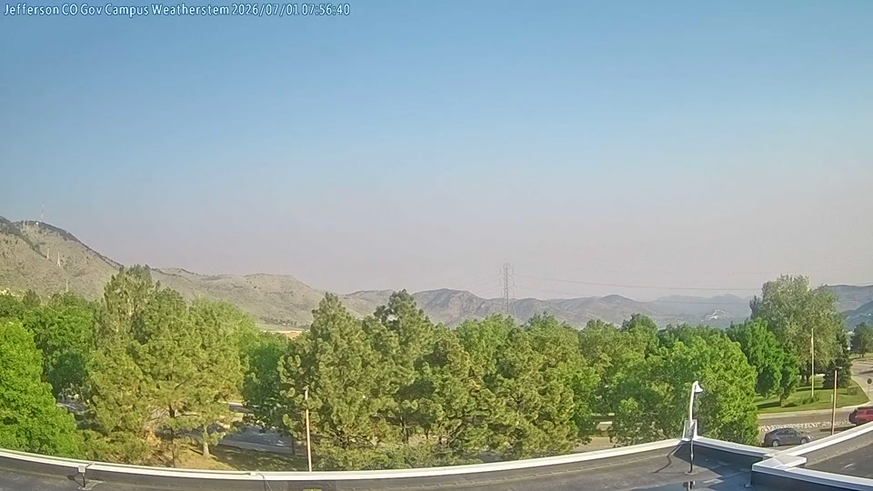 Wildfire smoke over mountainous terrain as emergency managers monitor Fire Weather Watches and Red Flag Warnings